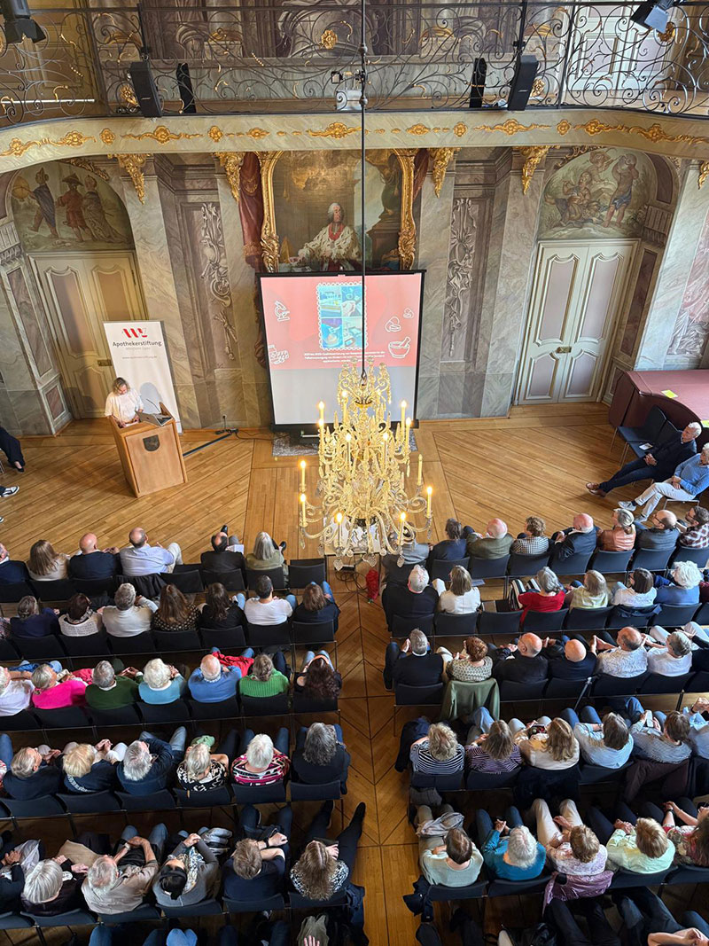 18_stiftungsveranstaltung_saal_von_oben_web Aufnahme eines prunkvollen Saals mit Kronleuchter, in dem ein Vortrag vor Publikum stattfindet, von oben